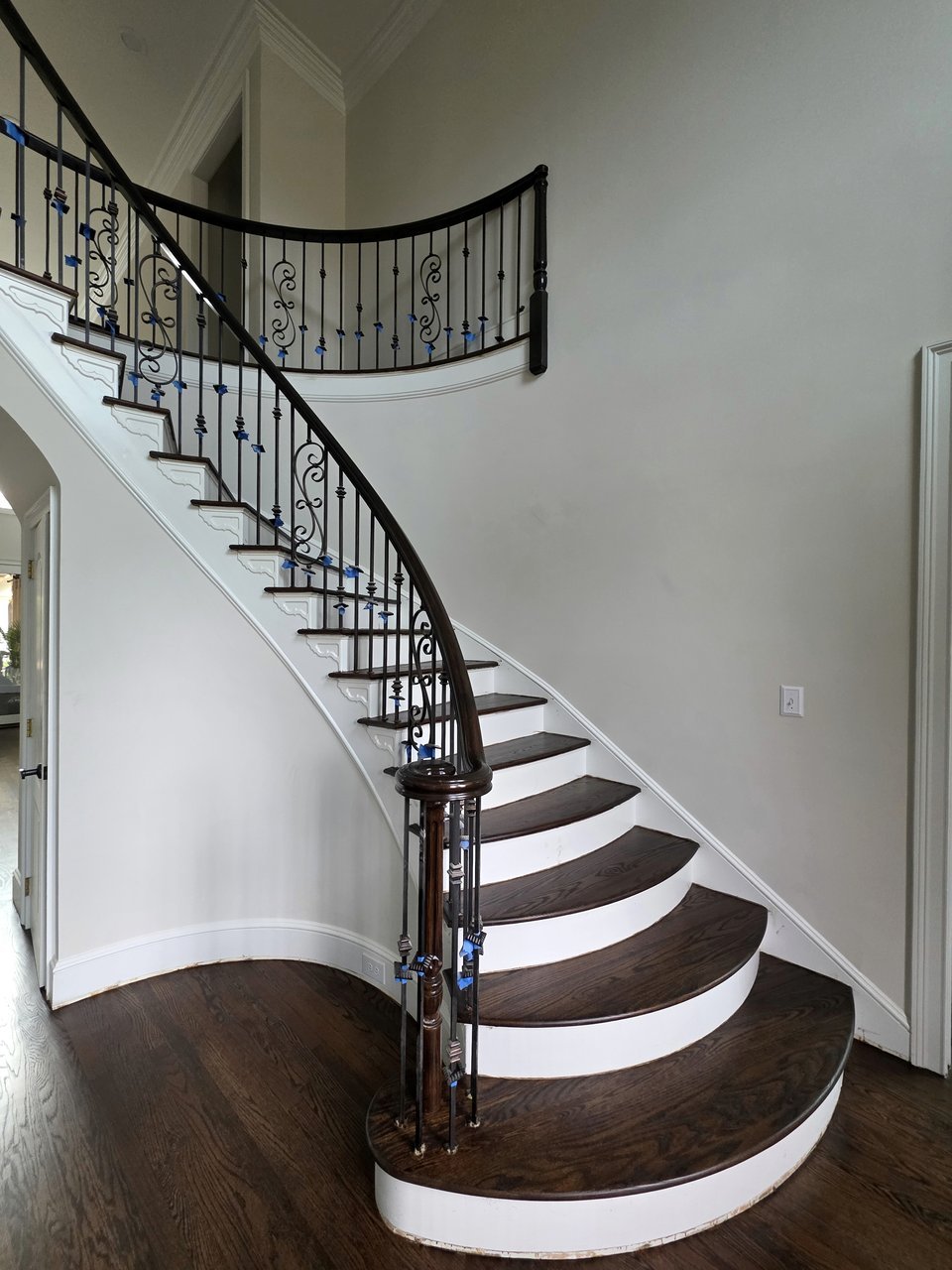 Curved staircase with white risers and dark wood treads