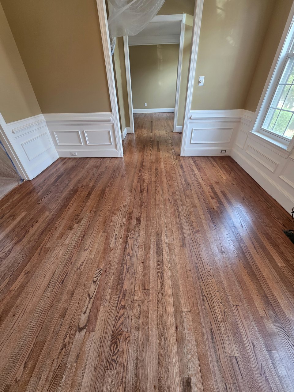 Wood floor beside paneled dining-room walls