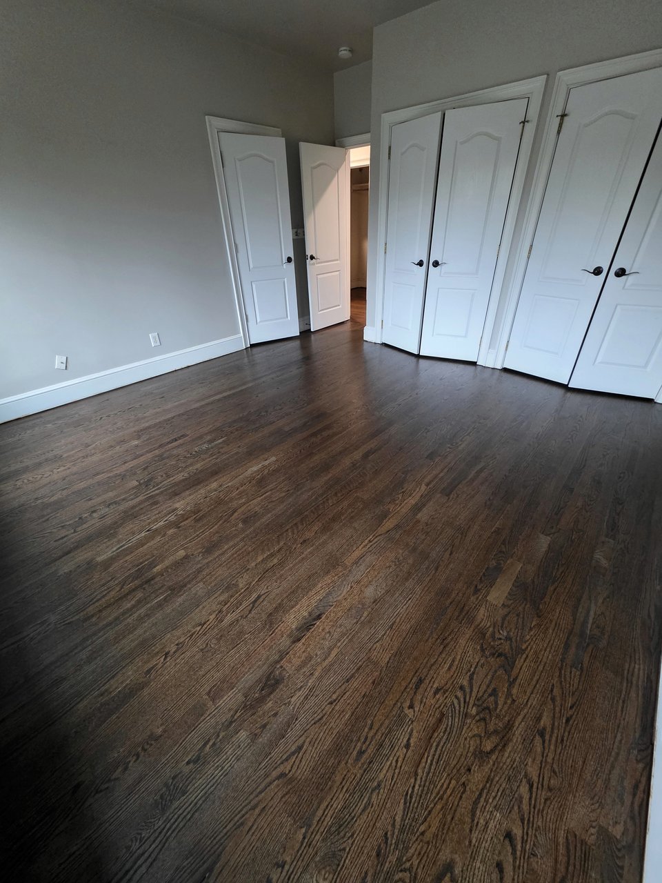 Wood floor in an empty room with white trim