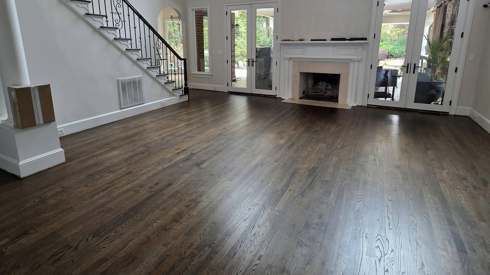 Refinished dark wood floor in a bright double-height living room