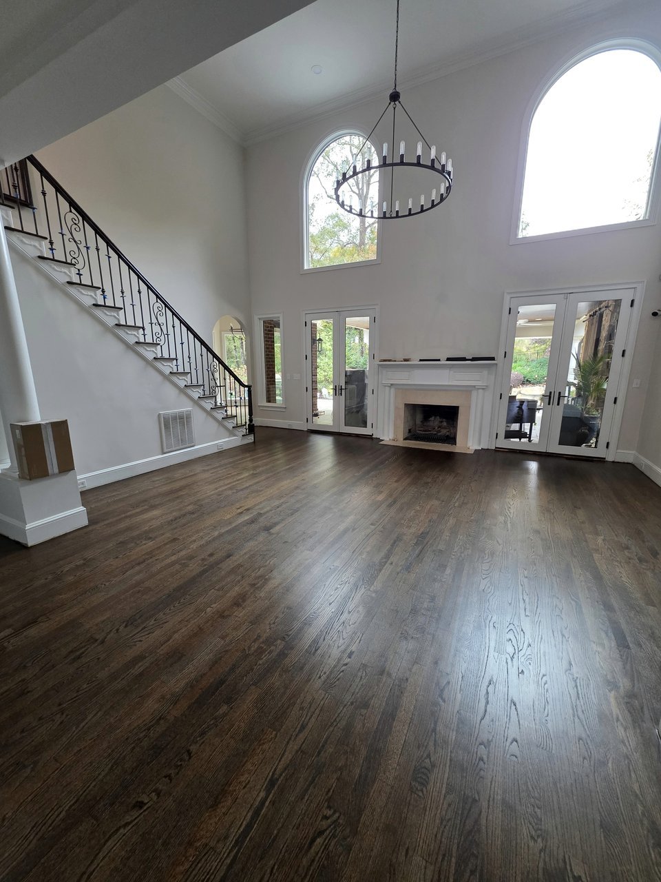 Dark wood floor beneath tall living-room windows