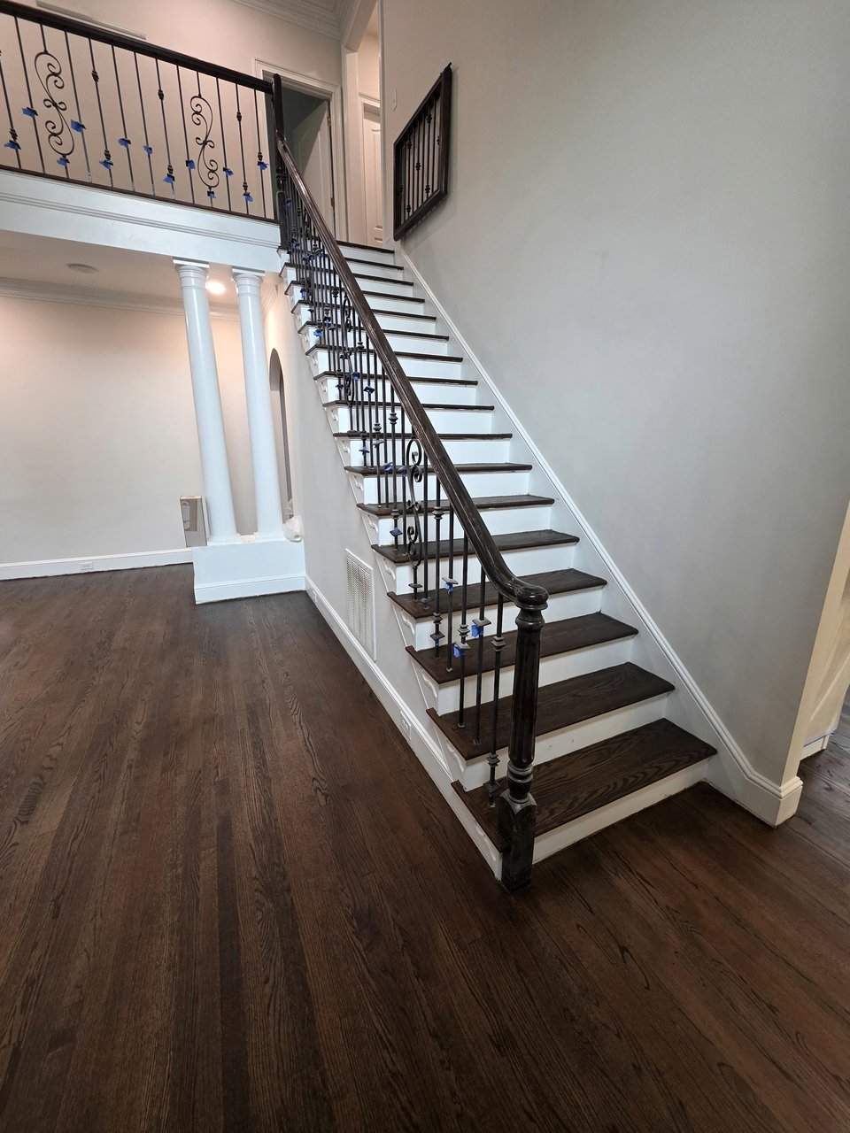 Curved wood staircase with iron balusters